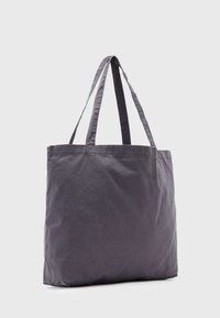 Pilkos audinio rankinė su dviem petnešomis, stačiakampio formos, lygaus paviršiaus ir minimalistinio dizaino. Be matomų detalių ar raštų.