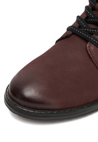 Burgundi värvi sünteetilisest nahast king ümarate varvastega, mustade paelade ja kontrastse õmblusega. Sile tekstuur kerge läikega.