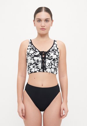 Top de flores en blanco y negro con un diseño corto y un cierre de cordones en el frente, combinado con unas braguitas de bikini negras de cintura alta. Tela suave y diseño ajustado.