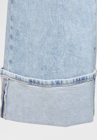 Svetlomodré riflové nohavice s olemovaným lemom, s jemne vyblednutým efektom a štandardnými švami pozdĺž švov.