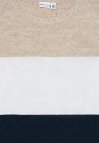 Genser med horisontale striper i beige, hvit og mørk marineblå, merket "basic needs by name it," størrelse 9-10 år, 134-140 cm.