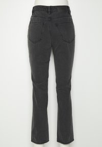 Jeans de ganga pretos com um corte justo, apresentando dois bolsos traseiros, uma cintura com uma etiqueta e um design dealtura média.