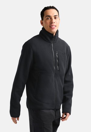 Black ribbed fleece jacket with a high collar, zippered pockets, and a streamlined fit. Features a textured surface for warmth and comfort.