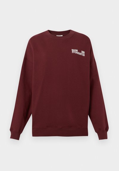 Μπορντό φούτερ με μακριά μανίκια, στρογγυλή λαιμόκοψη και λευκό λογότυπο με το κείμενο "BAUM UND PFERDGARTEN" στο μπροστινό μέρος. Μαλακή υφή υφάσματος.