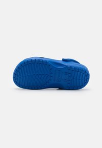 Blue rubber clogs featuring a textured sole with a tread pattern, a strap on the upper, and brand logo embossed on the side.