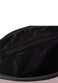 Öffene schwarze Tasche, die ein glattes schwarzes Innenfutter mit einer Reißverschlusstasche entlang der oberen Kante offenbart. Die Tasche besteht aus einem weichen Material.