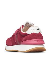 Sneaker in suede rosso e tessuto con un accento bianco sul tallone. Presenta una suola bianca spessa e una soletta rosa. I lacci sono di un rosso abbinato.