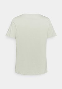 Camiseta de manga corta verde claro, hecha de algodón suave, con un cuello redondo y un diseño liso con un pequeño detalle impreso en la manga.