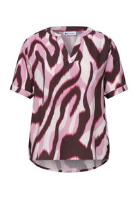 Blouse manches courtes avec motif abstrait zébré rose, blanc et marron foncé, fente en V et poignets retroussés.