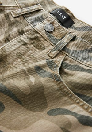 Beige Shorts mit Camouflage-Muster, ausgestattet mit einem Metallknopf, einem genähten Bund und einem Stoffetikett auf der Rückseite, das eine strukturierte Oberfläche zeigt.
