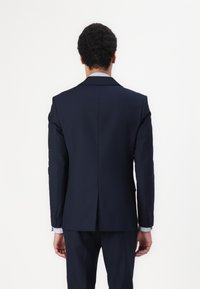 Navy suit jacket with notch lapels, single vent at the back, and four-button cuffs. Fabric appears smooth with a tailored fit.