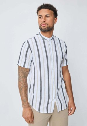 Une chemise à manches courtes avec boutonnière présente des rayures blanches, grises et beiges alternées. Fabriquée en tissu léger, elle dispose d'un ourlet arrondi et d'un col montant.