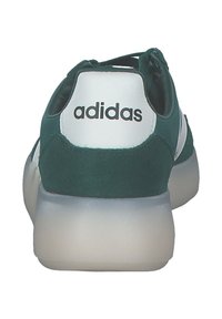 Zelené semišové tenisky s bílými detaily a značením. Vyznačují se zaobleným designem a průhlednou gumovou podrážkou.