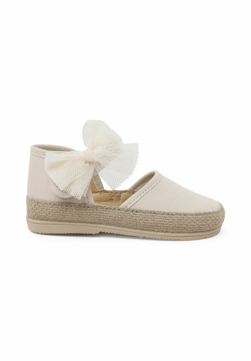 Chaussure espadrille beige avec semelle en jute tressé et grand nœud en tulle à la cheville, conçue pour un usage décontracté.
