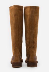 Stivali alti in suede marrone con una texture liscia, forma eretta e tacco in legno, caratterizzati da dettagli di cucitura verticale lungo il retro.
