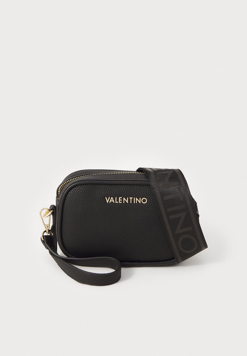 Svart teksturert skinnveske med glidelås, gulllogo og avtagbar stropp med et logo mønster.