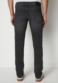 Ciemnoszare dżinsy o slim fit, z dwoma tylnymi kieszeniami i metką na pasku. Materiał ma gładką fakturę i lekki połysk.