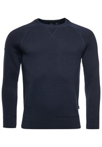 Maglione collo giro blu navy in tessuto lavorato a maglia con maniche lunghe, design a raglan e polsini e orlo a coste. Dettaglio di cucitura sottile sul collo.
