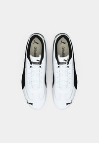 Hvide sneakers med sorte ruskind detaljer, der har en glat syntetisk overdel, snørebåndslukning og Ortholite indersål. Puma-logo på tunge.