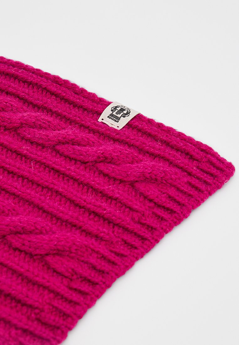 Fuchsia gestrickte Mütze mit geripptem Muster und Zopfmuster, ausgestattet mit einem kleinen rechteckigen Stoffetikett am Rand.