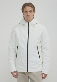 Weiße Kapuzenjacke mit glatter Textur, ausgestattet mit einem durchgehenden Reißverschluss an der Vorderseite und zwei schwarzen Reißverschlusstaschen. Einfaches Design mit minimalen Akzenten.