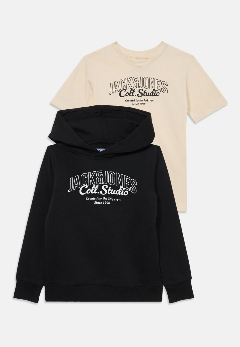 Juodas džemperis su kišene priekyje ir baltu logotipo tekstu, uždėtas po šviesiai rudų trumpomis rankovėmis marškiniais su juodu logotipo spaudiniu.