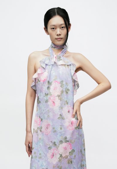 Virágos nyakbakötős ruha orgonalila alapon rózsaszín rózsákkal, fodros nyakkivágással és hozzáillő sállal. Könnyű, légies anyag, puha tapintású.