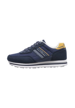 Zapatillas de deporte azul marino con materiales de ante y malla, con cordones blancos, acentos amarillos y rayas horizontales en el lateral. Suela de goma.