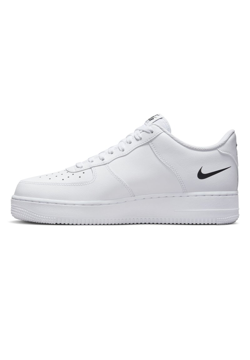 Białe niskie trampki Nike Air Force 1 z czarnym logo swoosh, sznurowanym przodem i perforowaną czubkiem na białej podeszwie, widok z boku.