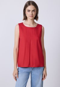 Top sin mangas rojo hecho de una tela suave, con un escote redondo y un corte relajado, complementado por un diseño simple y sin patrones adicionales.