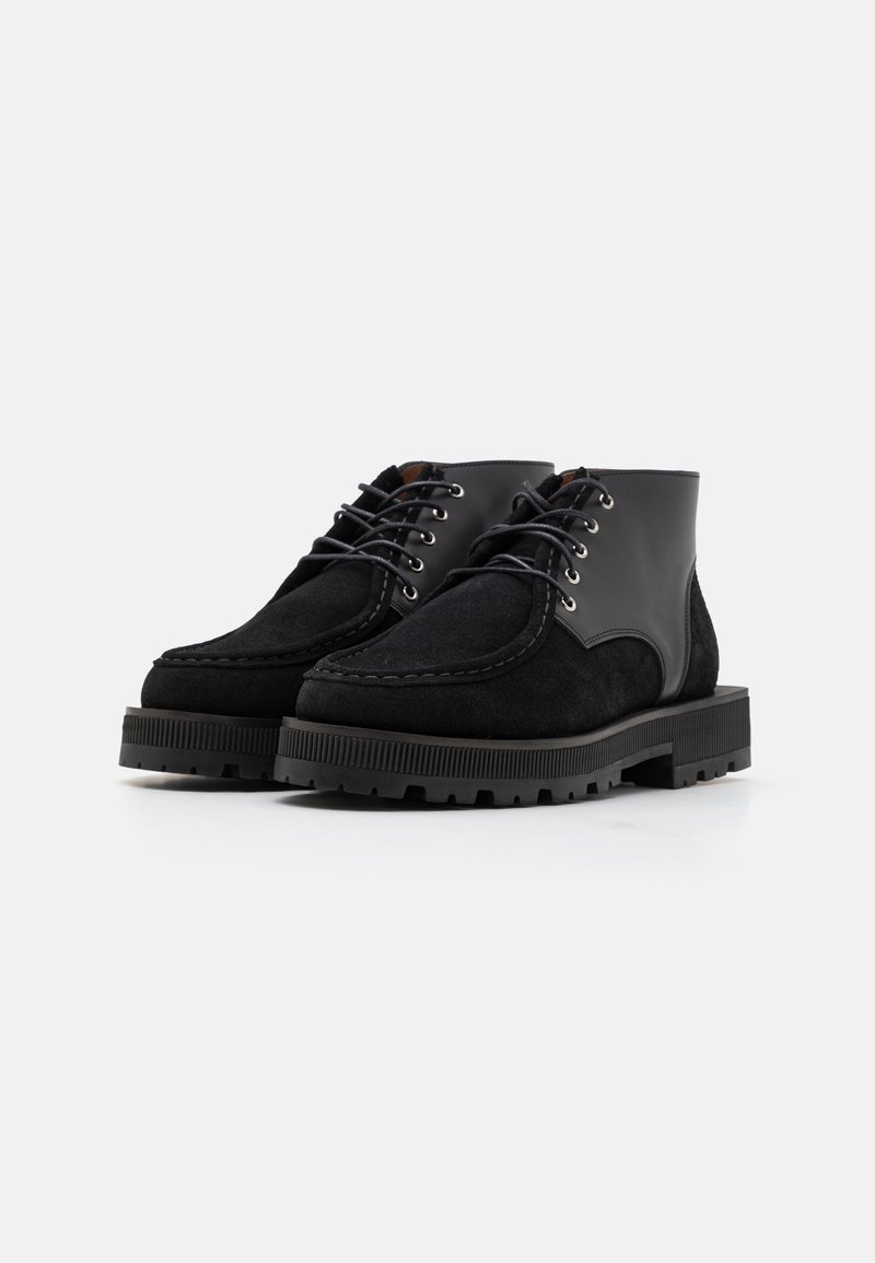 Bottines en daim noir et cuir, avec bout rond, design à lacets, et semelle en caoutchouc dotée d'un crantage texturé pour une meilleure adhérence.