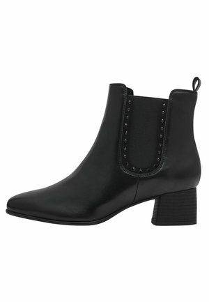 Bottines noires en cuir lisse avec des panneaux élastiques sur les côtés et des clous décoratifs. Dotées d'un talon bloc épais et d'un design à bout pointu.