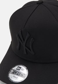 Schwarze Baseballmütze aus Stoff, mit einem 3D-gestickten Logo. Enthält ein rundes Etikett, das "9FORTY" und "Child" für eine verstellbare Passform angibt.