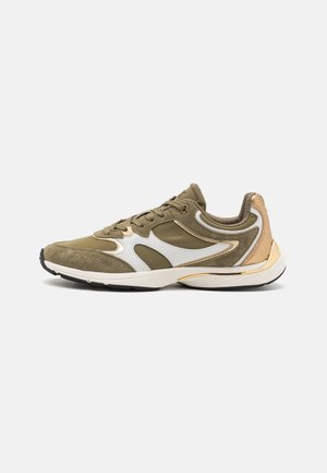 Vue de profil d'une basket de sport olive et beige avec des accents blancs et une semelle blanche épaisse sur un fond uni.