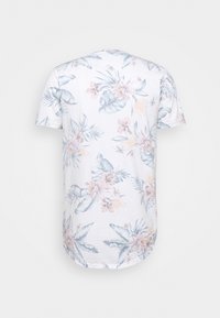 Kortärmad T-shirt i vit bomull, med ett pastellblommönster med blad och blommor. Rund halsringning, böjd nederkant.
