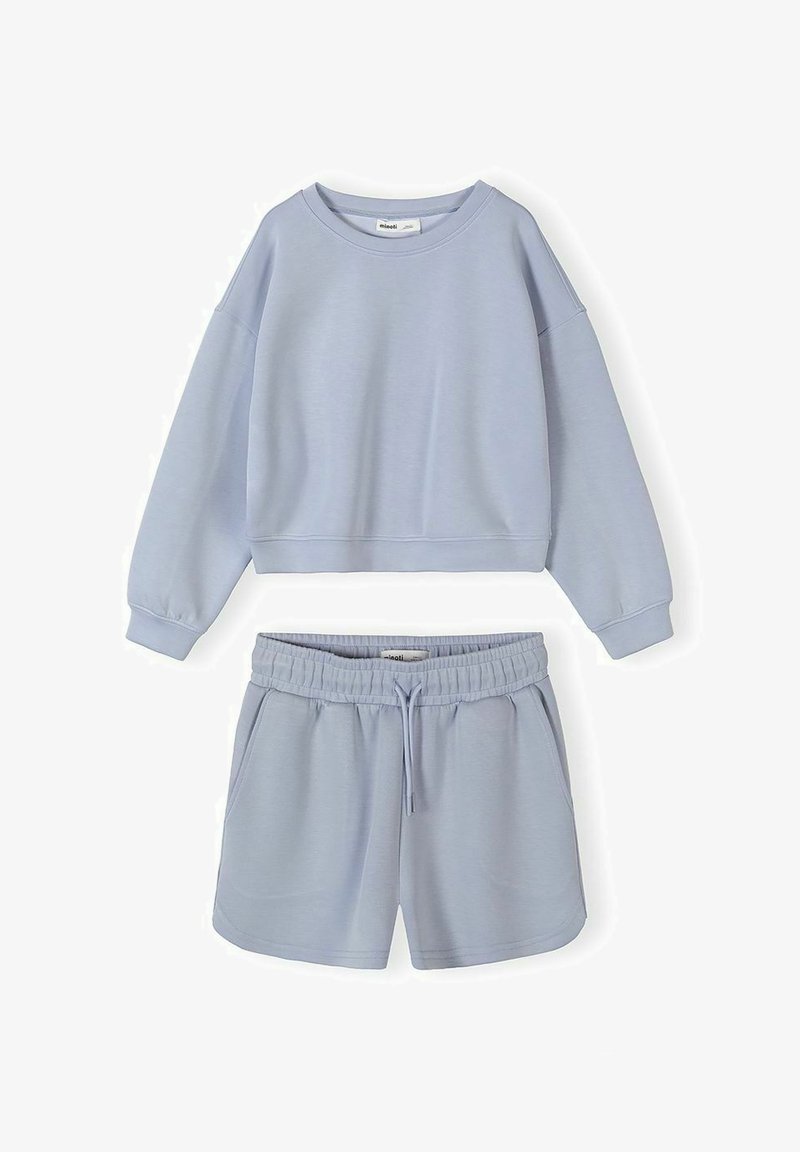 Tenue décontractée bleu clair composée d'un sweat-shirt court à manches longues et d'un short à taille élastique avec cordon de serrage, fabriqués à partir d'un tissu doux.