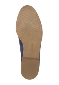 Blå mockaskor med en texturerad brun gummisula. Har en logotypprägling och en slät yta. Rundade kanter utan ytterligare detaljer.