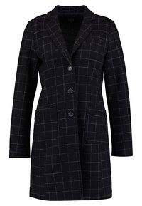 Blazer long noir avec motif à carreaux blanc, trois boutons à l'avant, deux poches latérales et col cranté.