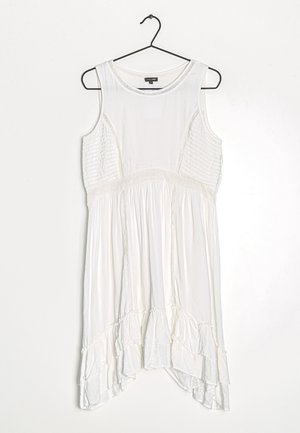 Weißes ärmelloses Kleid mit strukturierten Seitenpaneelen, einer gerafften Taille und einem Rüschensaum. Angenehmer Stoff, lockere Passform und runder Ausschnitt.