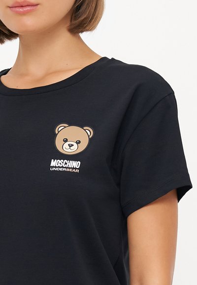 Black cotton t-shirt featuring a brown bear graphic and "MOSCHINO UNDERBEAR" text in white and light beige. Classic crew neck design.