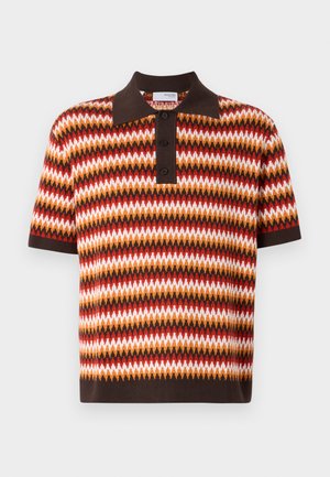 Short-sleeve, collared polo shirt in a zigzag pattern with red, orange, brown, and white colors; features three buttons and a contrasting collar.