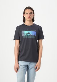Mørkegrå bomulls-t-skjorte med et rektangulært grafisk design med palmer og tekst i blå og grønne nyanser på forsiden. Kortermet.