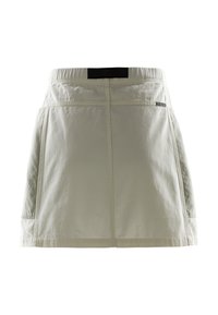 Ljusbeige skorts med resårmidja, två sidfickor och en slät yta. Har mörk nät detalj vid midjan.