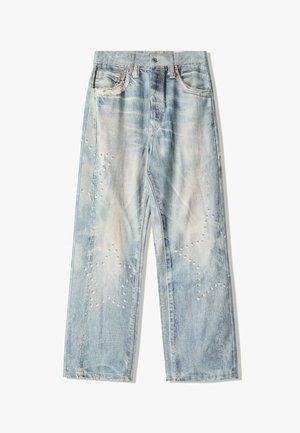 Bleget blå denim jeans med løs pasform, der har slidte mønstre og dekorative nitter arrangeret i stjernemønstre på forsiden.