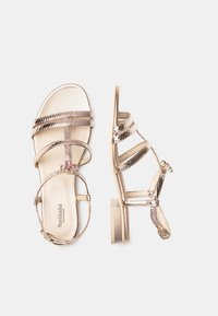 Sandali a strappo metallici dorati con tacco basso a blocco, caratterizzati da accenti decorativi e larghe bande per supporto. Fodera interna liscia.