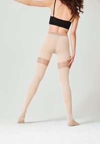 Collant beige con una finitura trasparente e testurizzata e una fascia solidale più scura all'altezza della coscia, che offre un design aderente e uno stile con piede.