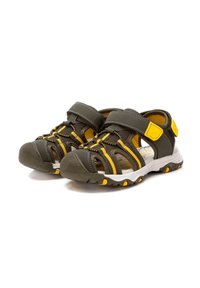 Sandalias deportivas de color verde oscuro y amarillo con un diseño abierto, correas ajustables, suela de goma texturizada y parte superior de malla para ventilación.