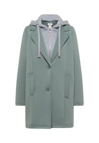 Manteau vert boutonné avec un sweat à capuche gris zippé en dessous, doté de cordons de serrage et de deux poches avant.
