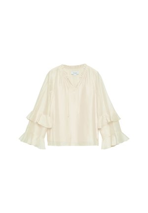 Jasnobeżowa bluzka z falbanami na dekolcie w kształcie litery V oraz rękawami o długości do połowy przedramienia zakończonymi dzwonkowato, z warstwowymi falbanami, luźnym krojem i troczkami do wiązania.