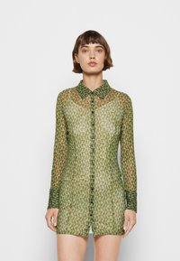 Vestido de camisa verde transparente com um padrão geométrico, apresentando colarinho, mangas longas e uma silhueta justa.